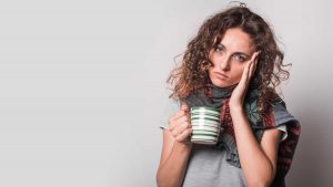 Tired woman holding coffee cup suffering from adrenal fatigue mistakes