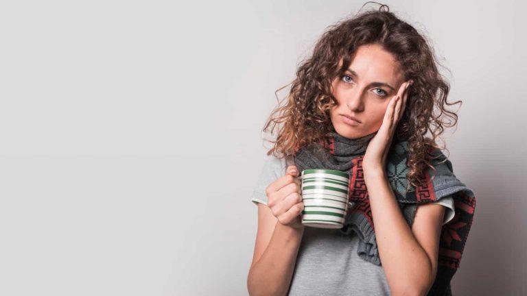 Tired woman holding coffee cup suffering from adrenal fatigue mistakes