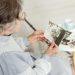 Senior woman looking thoughtful while holding a photo album, illustrating mom forgetting recent events