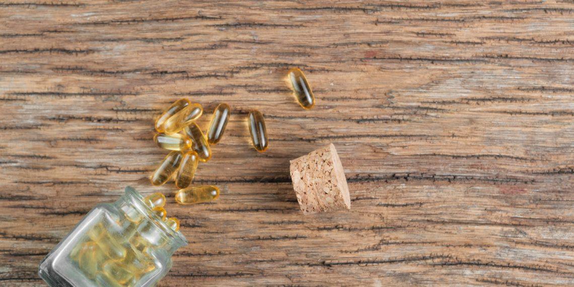Supplement bottle containing calcium beta hydroxybutyrate on a wooden table