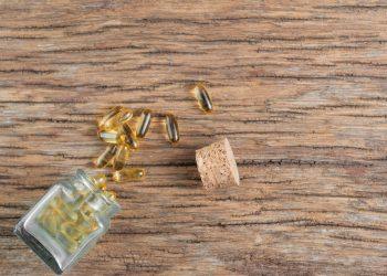 Supplement bottle containing calcium beta hydroxybutyrate on a wooden table