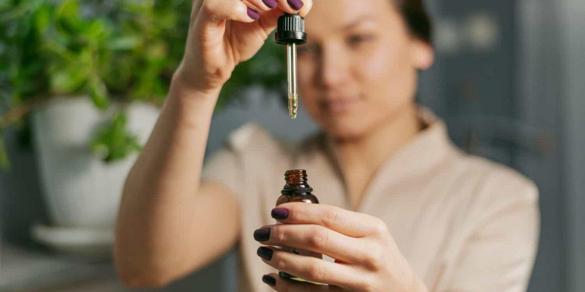 Woman using essential oils for tension headache relief