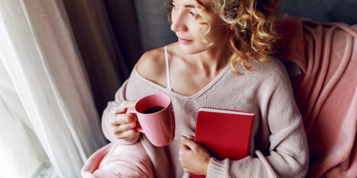 woman journaling in a sunlit room to express emotions
