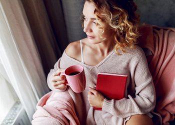 woman journaling in a sunlit room to express emotions
