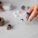 Hearing aid and wireless earbuds with accessories on a table.
