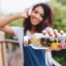 Young woman holding a fruit-infused water bottle labeled #Life.