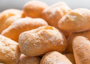 Freshly baked bread rolls stacked together.