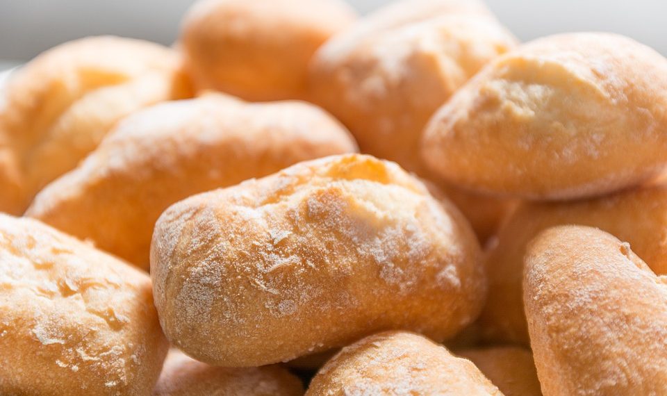 Freshly baked bread rolls stacked together.