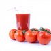 Tomato juice in a glass surrounded by fresh tomatoes.