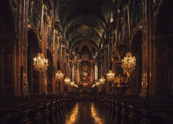 Grand cathedral interior with ornate chandeliers and detailed frescoes.