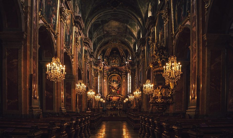 Grand cathedral interior with ornate chandeliers and detailed frescoes.