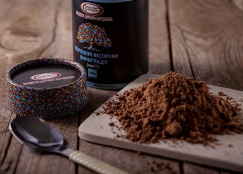 Grape seed powder on cutting board with spoon nearby.