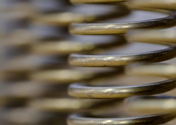 Golden metal coil with blurred background.