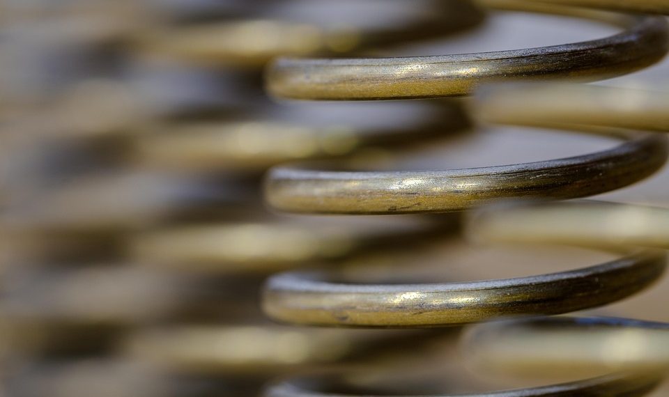 Golden metal coil with blurred background.