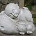 Sleeping monk stone statue in a peaceful garden setting.