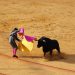 Matador skillfully evades a charging bull in the arena.