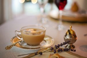 Elegant tea cup with saucer and lavender on a set dining table.
