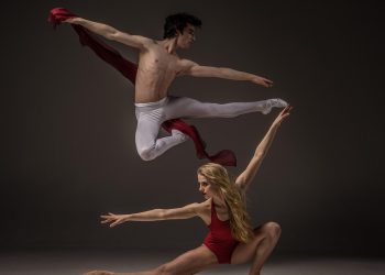 Ballet dancers performing a dynamic leap in elegant poses.