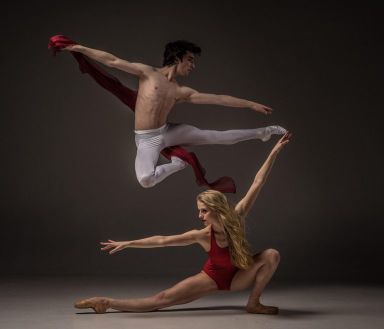 Ballet dancers performing a dynamic leap in elegant poses.