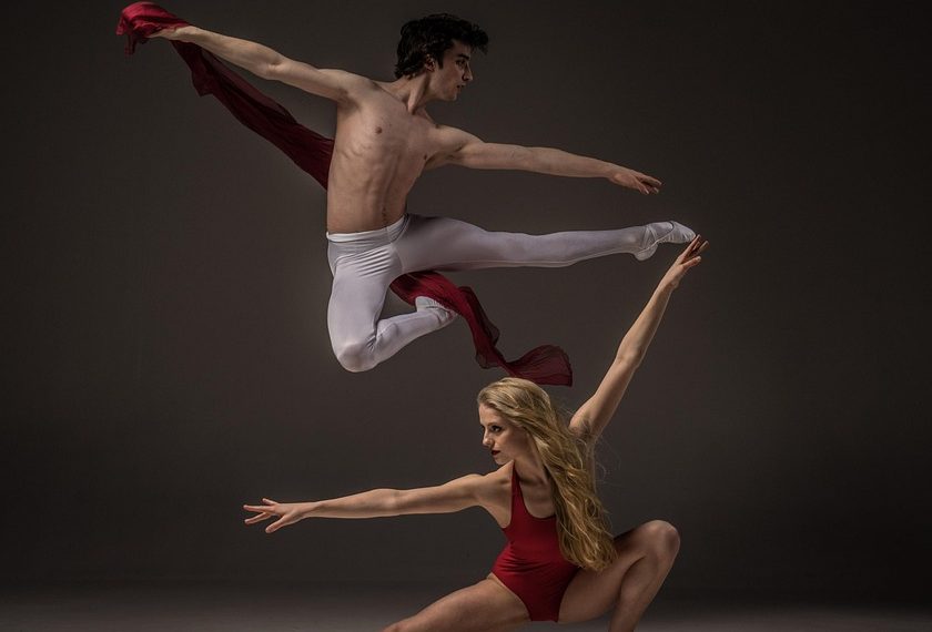 Ballet dancers performing a dynamic leap in elegant poses.