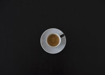 Cup of espresso on black table.