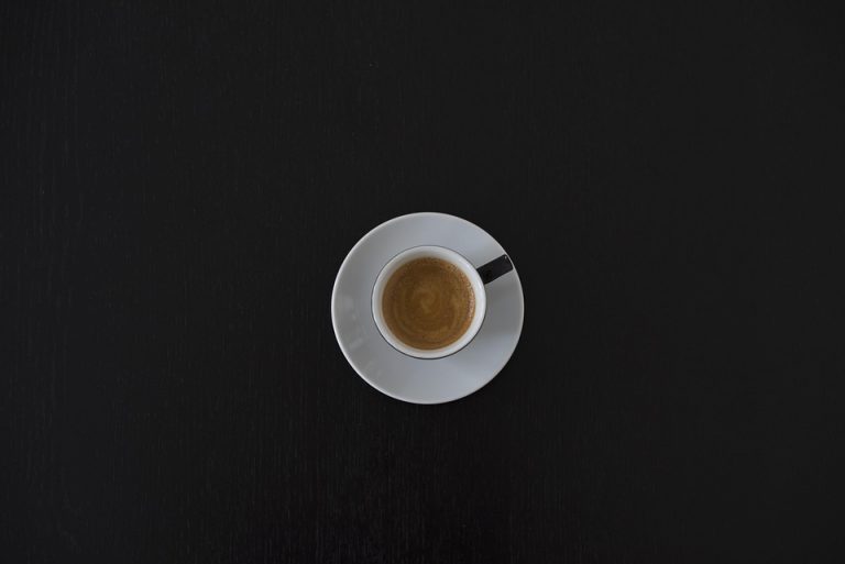 Cup of espresso on black table.