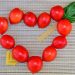 Cherry tomatoes and pasta form a heart shape on a woven mat.
