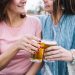 Two friends cheer with glasses of beer, smiling enjoying a moment to beer balance hormones