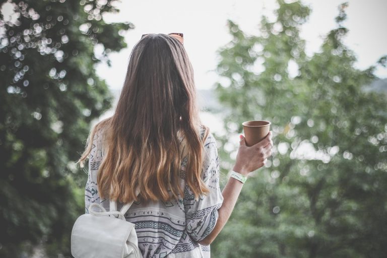 Woman with long hair enjoying outdoor coffee.
