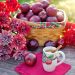 Basket of red apples with flowers and apple cinnamon tea on table.