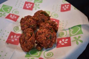 Pakoras served on decorative paper.