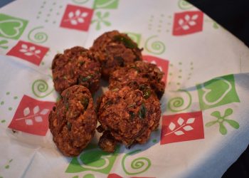 Pakoras served on decorative paper.