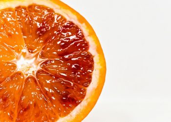 Half sliced blood orange on white background