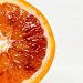 Half sliced blood orange on white background