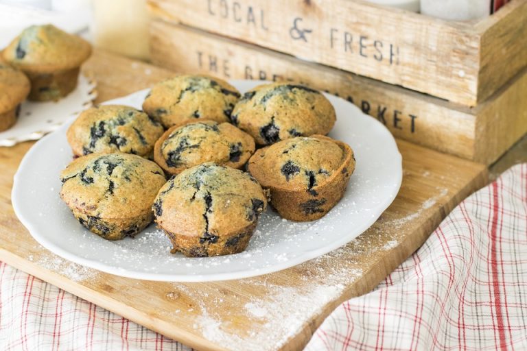 Freshly baked blueberry muffins on a plate.