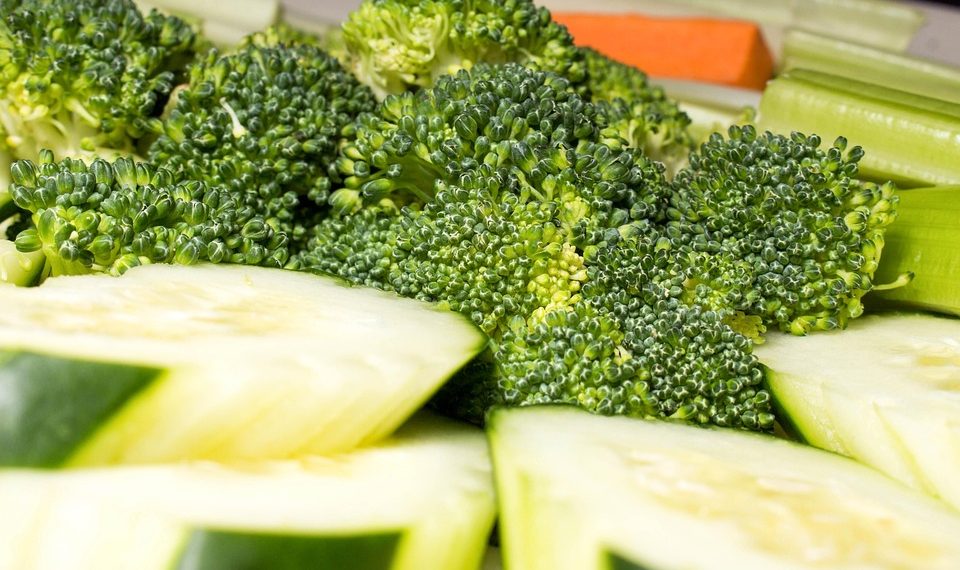 Fresh broccoli and sliced cucumbers presented with carrots and celery.