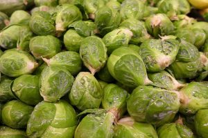 Fresh Brussels sprouts piled together with water droplets.