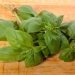 Fresh basil leaves on wooden cutting board