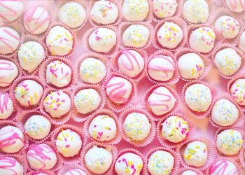 White chocolate cake balls topped with colorful sprinkles.