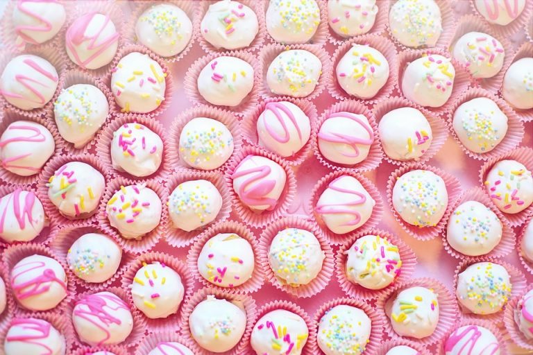 White chocolate cake balls topped with colorful sprinkles.