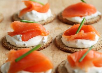 Fresh salmon on crackers with cream cheese and chives.