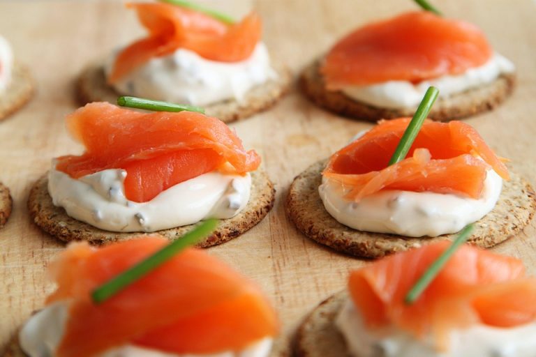 Fresh salmon on crackers with cream cheese and chives.