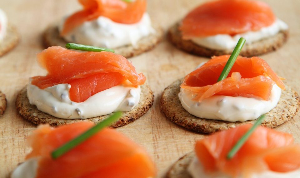 Fresh salmon on crackers with cream cheese and chives.