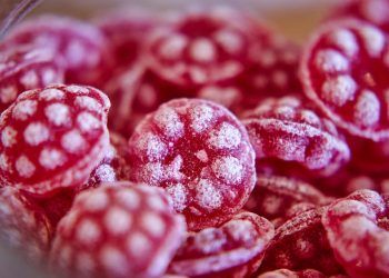 Red raspberry candies with sugar coating.