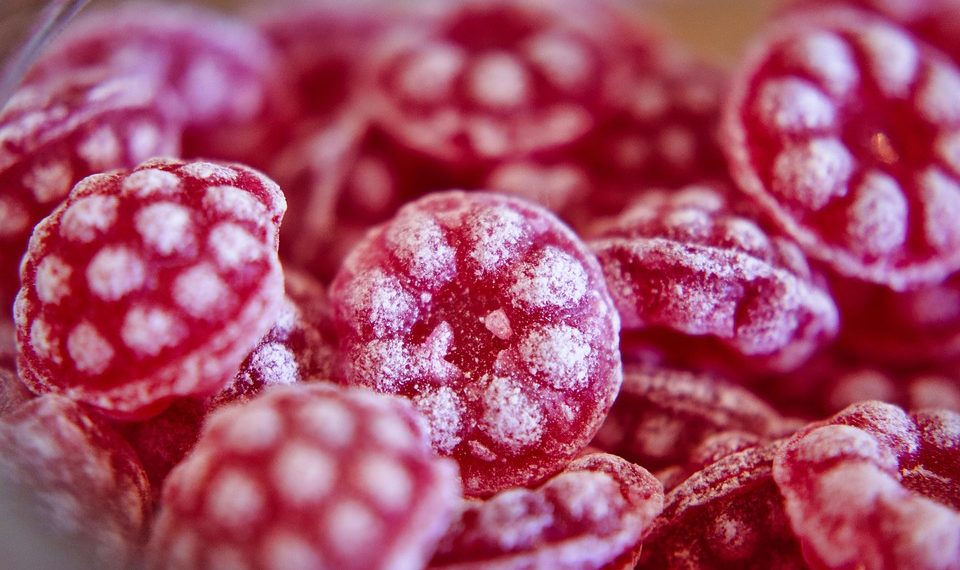 Red raspberry candies with sugar coating.