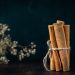 Cinnamon sticks tied with twine on dark background.