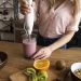 Blending fruit smoothie with immersion blender on wooden counter.