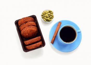 Pack of cookies with black coffee and spices on white background.