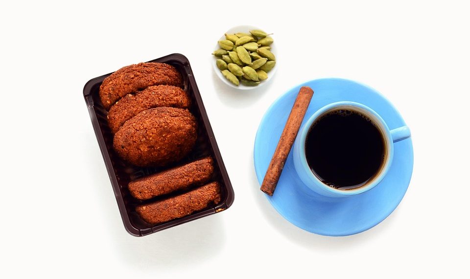 Pack of cookies with black coffee and spices on white background.