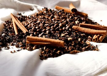 Cinnamon sticks and coffee beans on fabric.